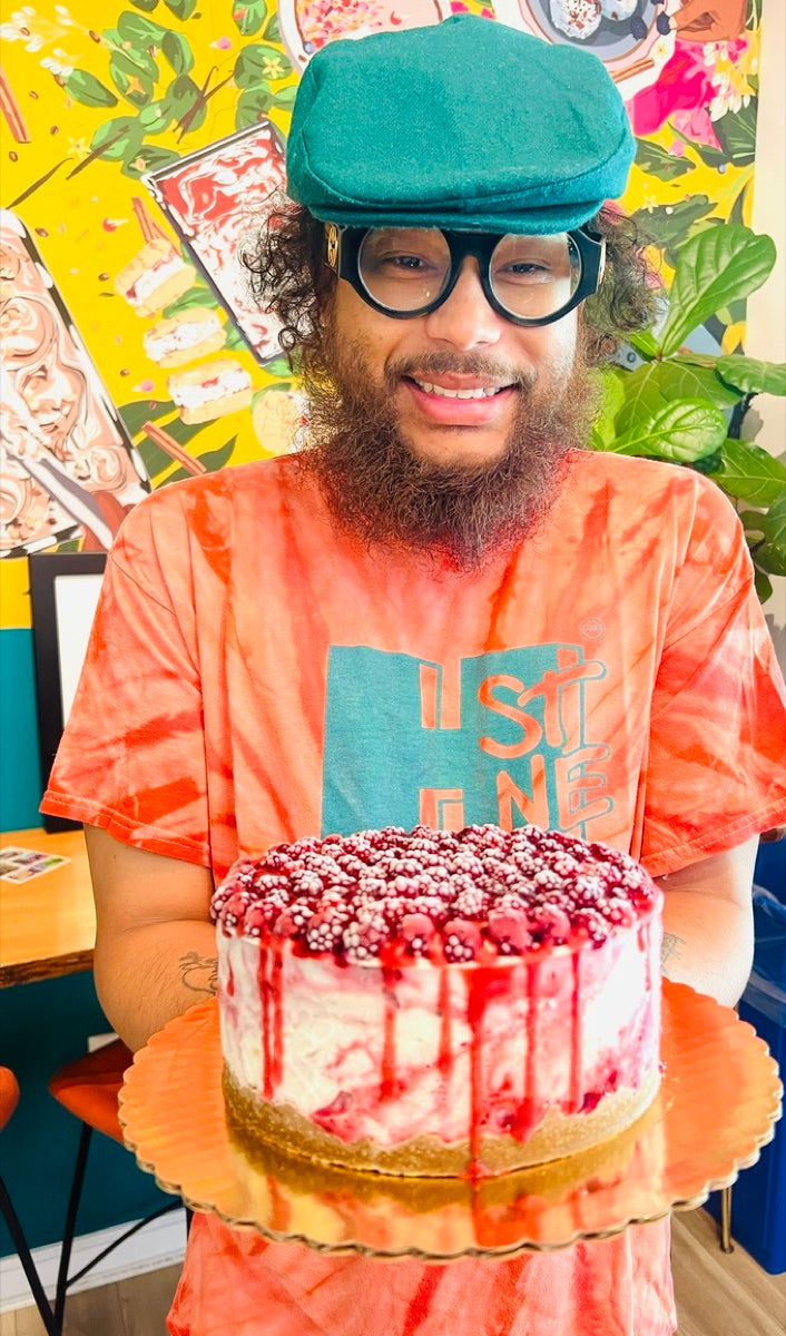A Cajou team member holding a berry ice cream cake